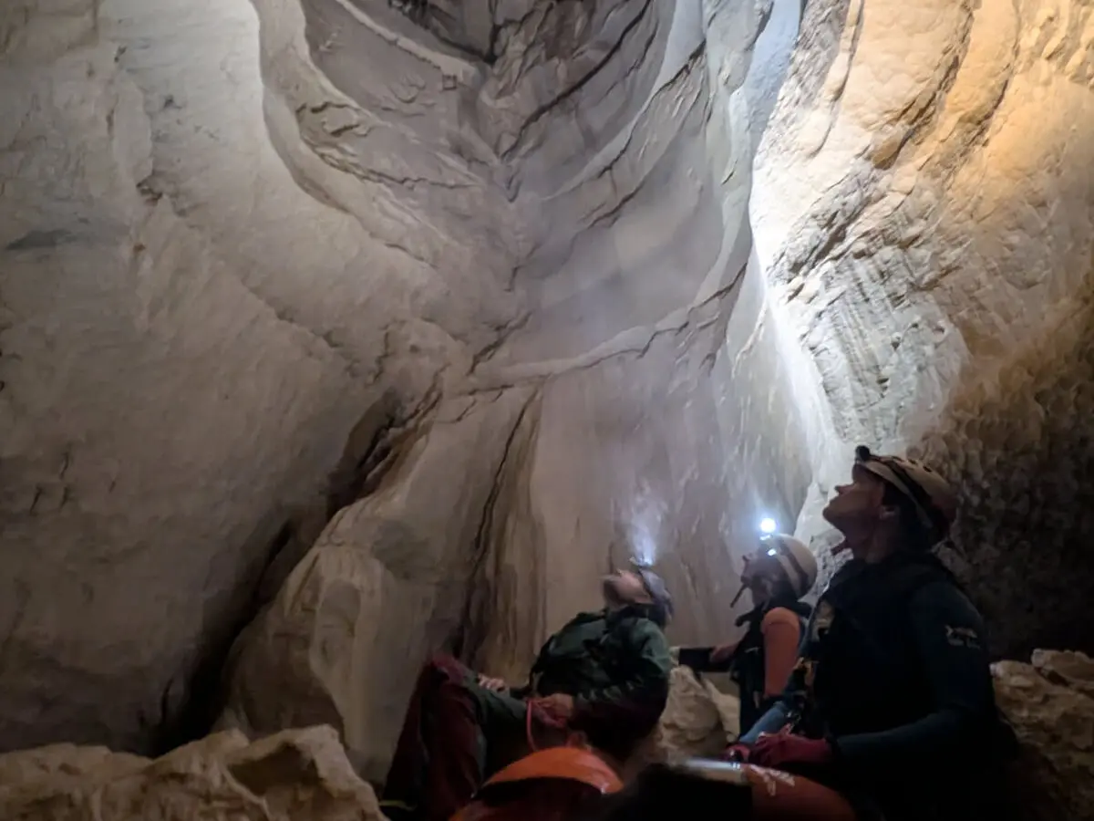 Spéléologues levant les yeux vers un grand puits dans la grotte de Gournier