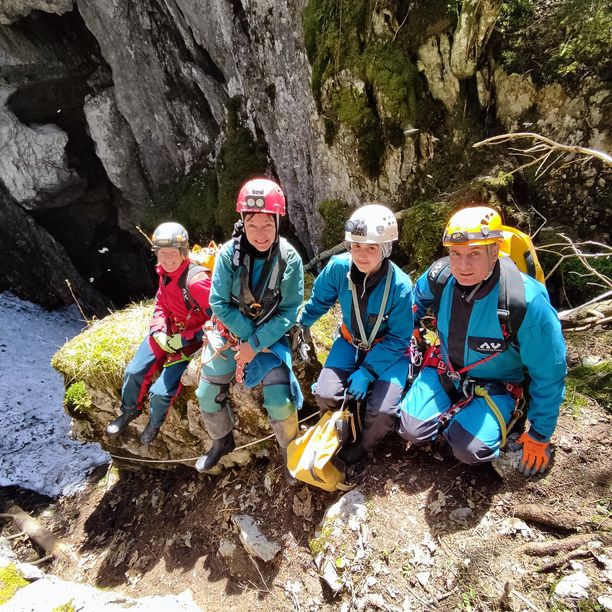 Canyonistes du club casqués, assis à l'entrée d'une gorge